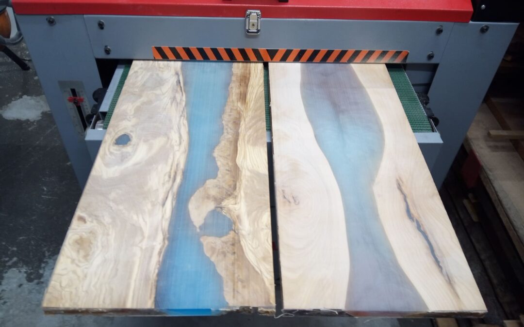 Ukázka z naší dílny – výroba epoxidových podnosů z olivového a třešňového dříví. Vyndání z odlévací formy, protažení a srovnání povrchu pomocí egalizační válcové brusky, zarovnání okrajů na míru a frézování ozdobných hran, broušení, leštění, natření olejem, montáž madel.